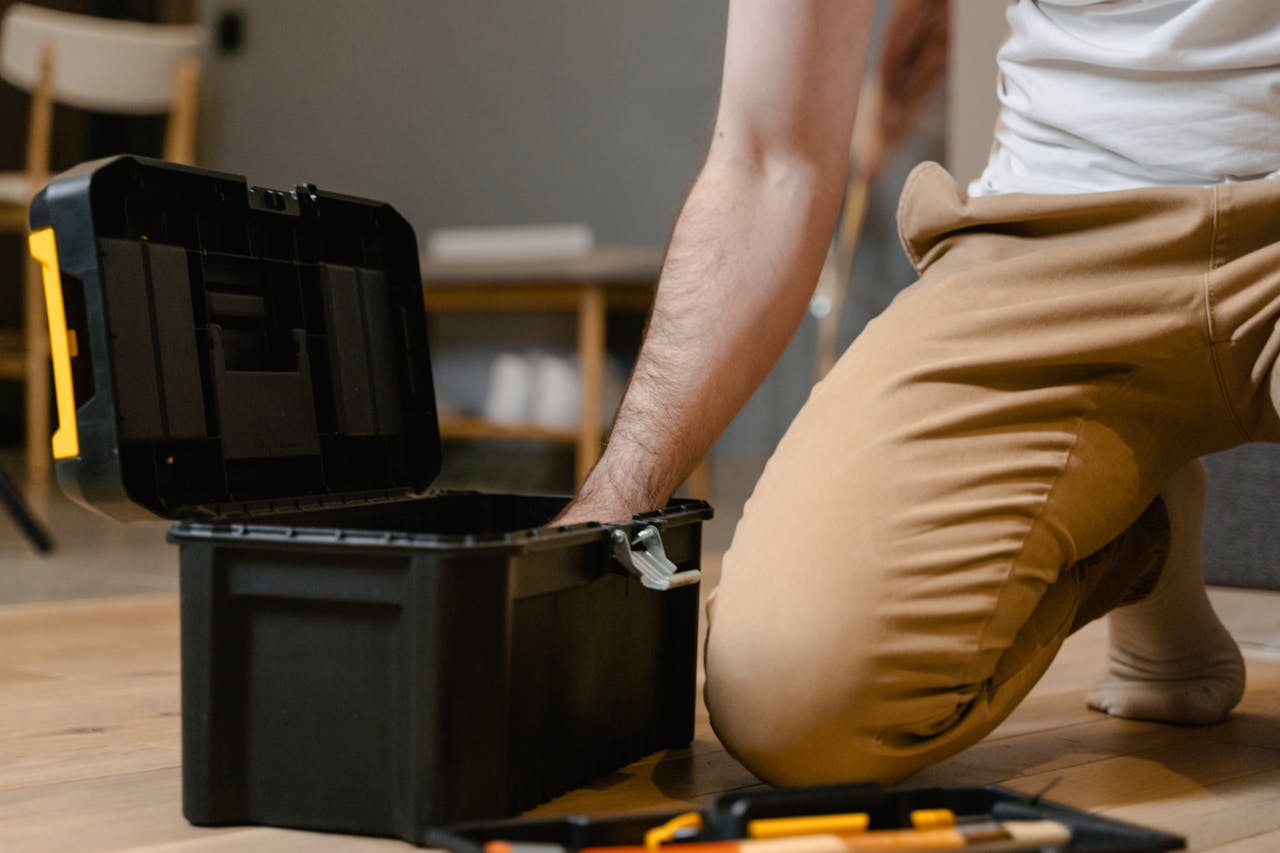 who-we-are A man opening a tool box indoors, preparing for home repair.