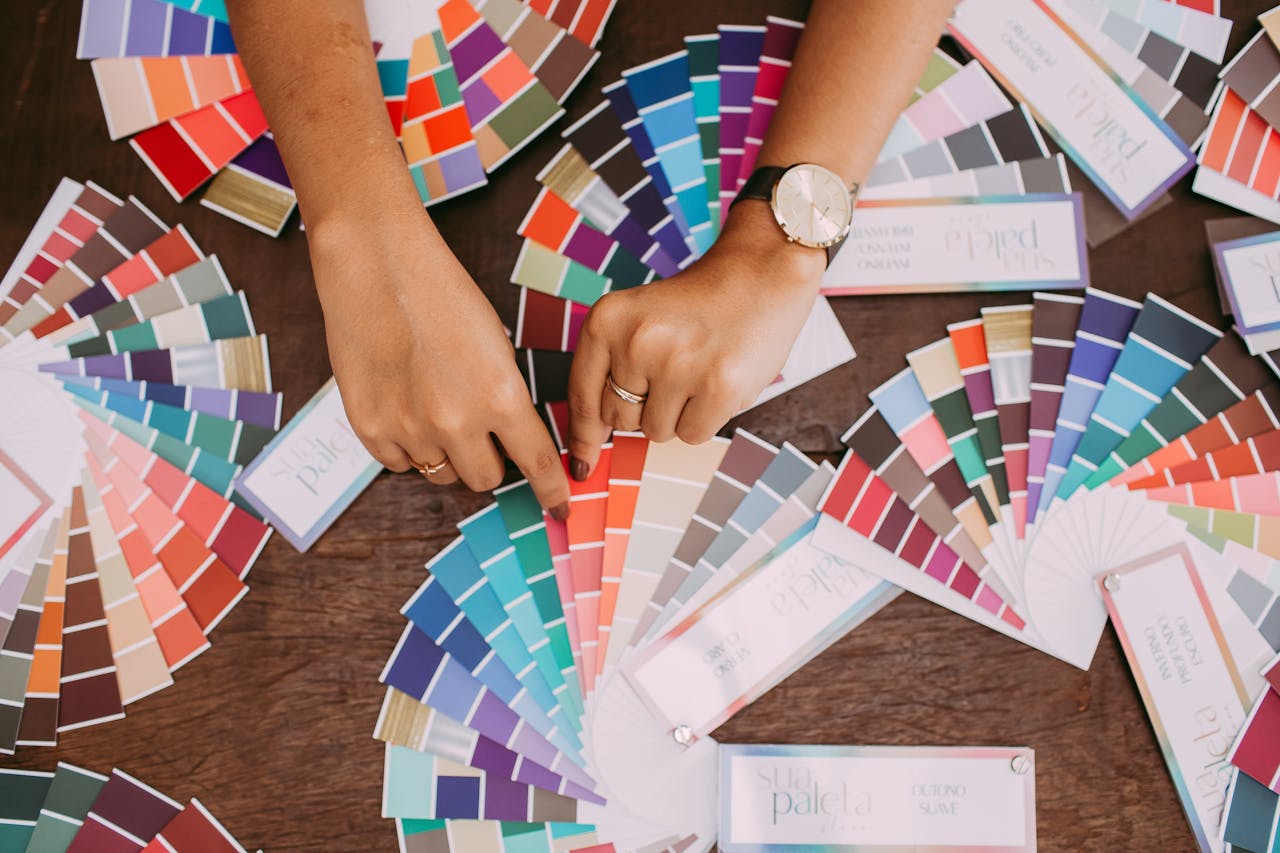 about-img Hands examining colorful fabric swatches on a table, highlighting design choices.